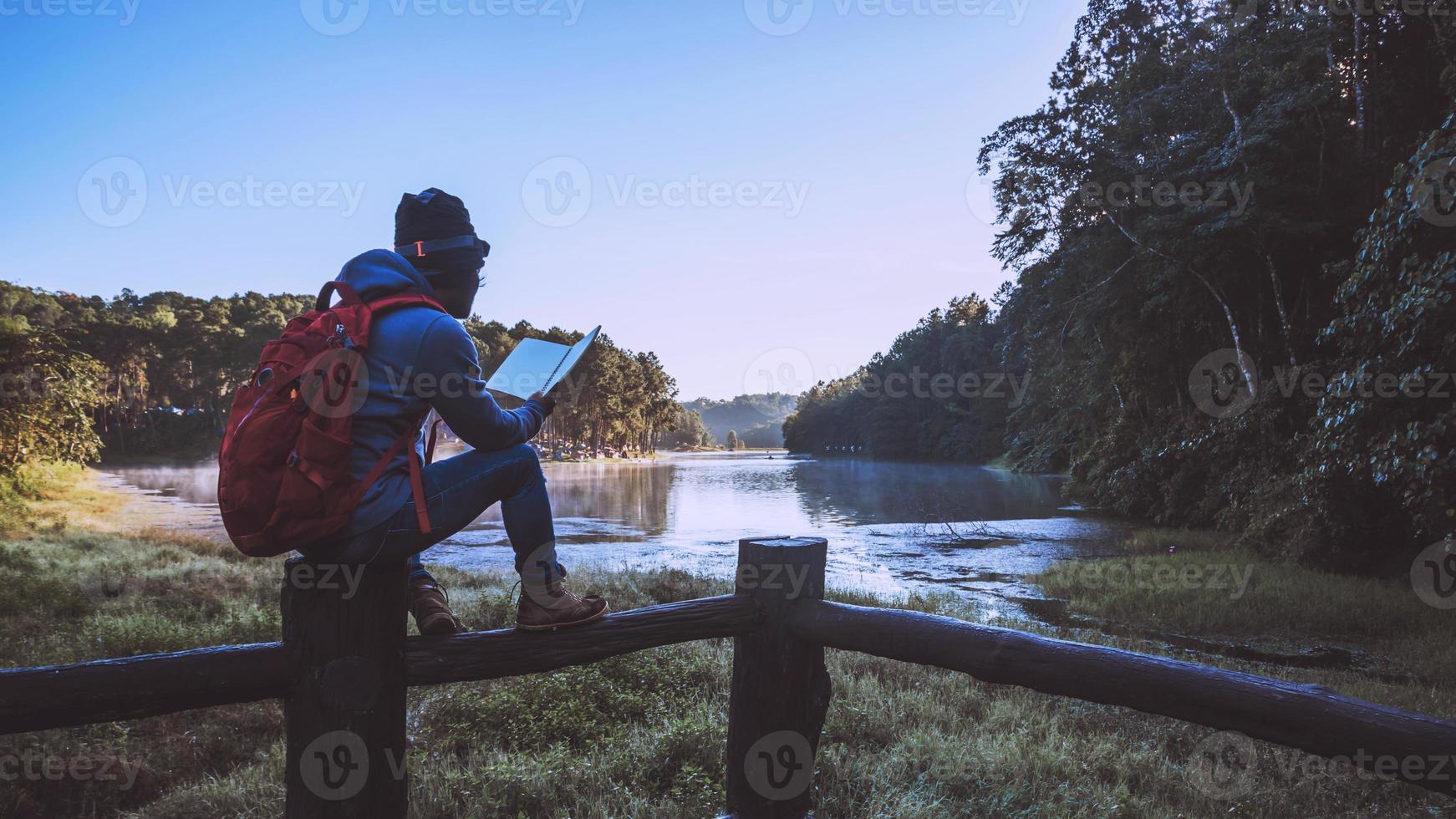 viaje de hombre asiático relajarse en las vacaciones. Asientos relajarse leer libros entre los hermosos paisajes de pang ung, Tailandia foto