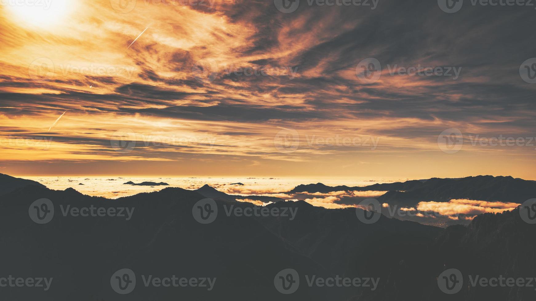 Alpine panorama with low clouds between the mountains photo