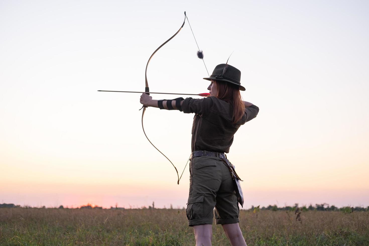 woman with bow outdoors in the field photo