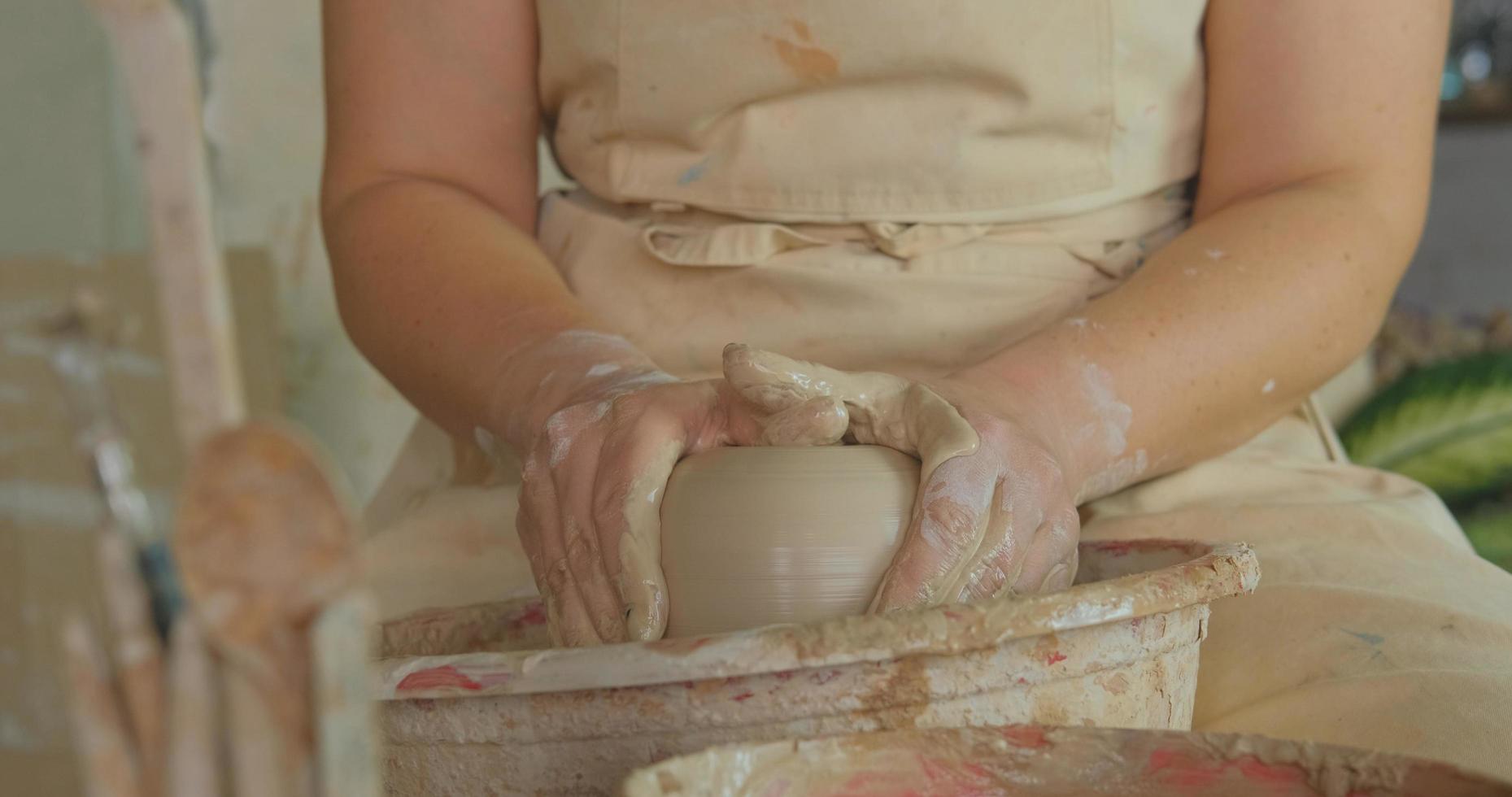 Close up of womans hand work with clay in pottery studio photo