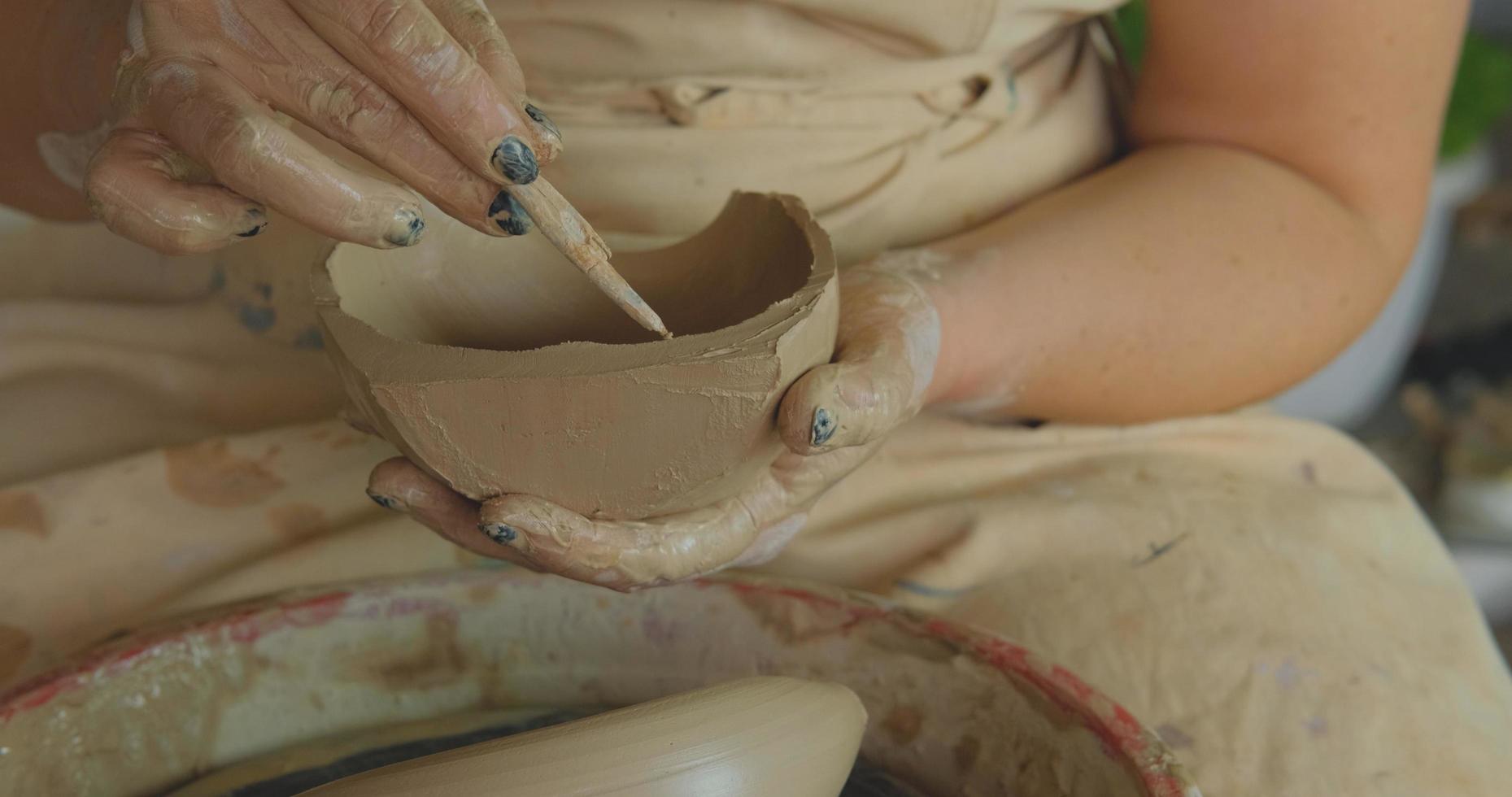 Close up of womans hand work with clay in pottery studio photo
