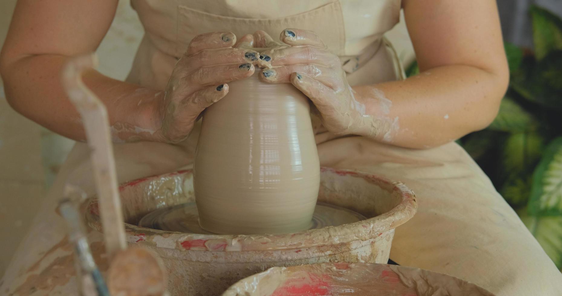 Close up of womans hand work with clay in pottery studio photo