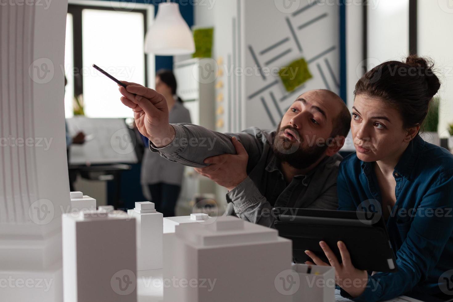 Equipo de arquitectos de la construcción trabajan en tableta en la oficina foto