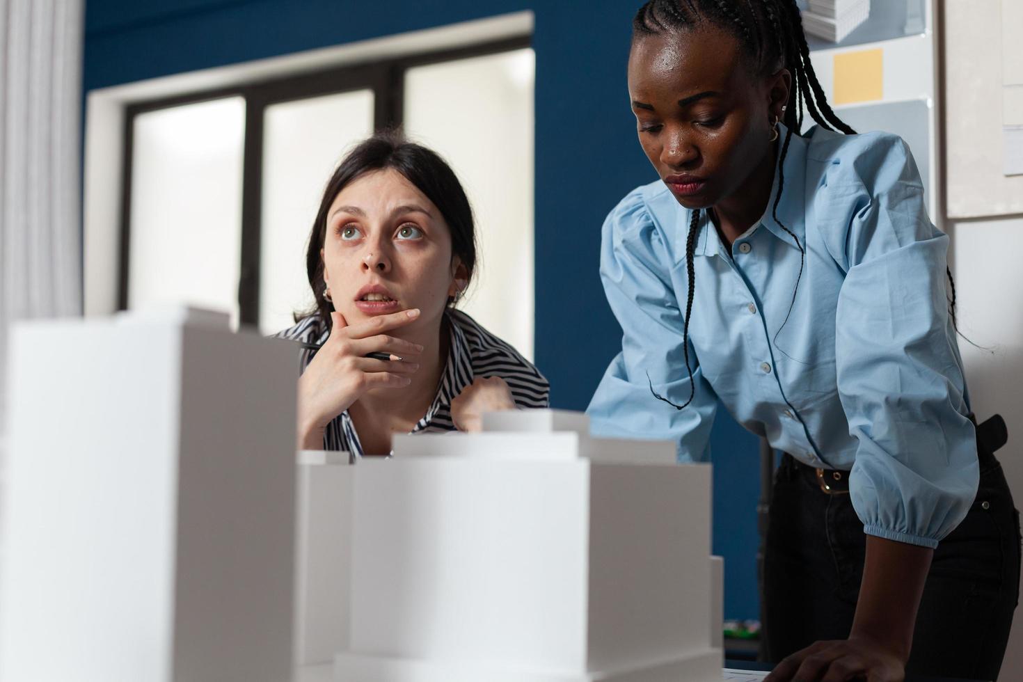 Mujeres de profesión de arquitecto de pie en la oficina de escritorio foto