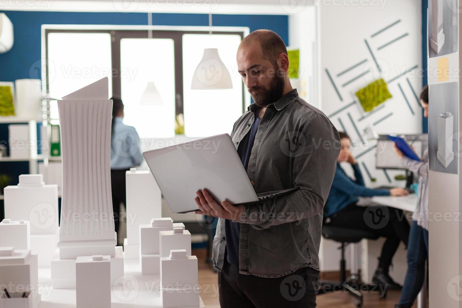 Arquitecto adulto urbano inspeccionando el plan de diseño en el lugar de trabajo foto