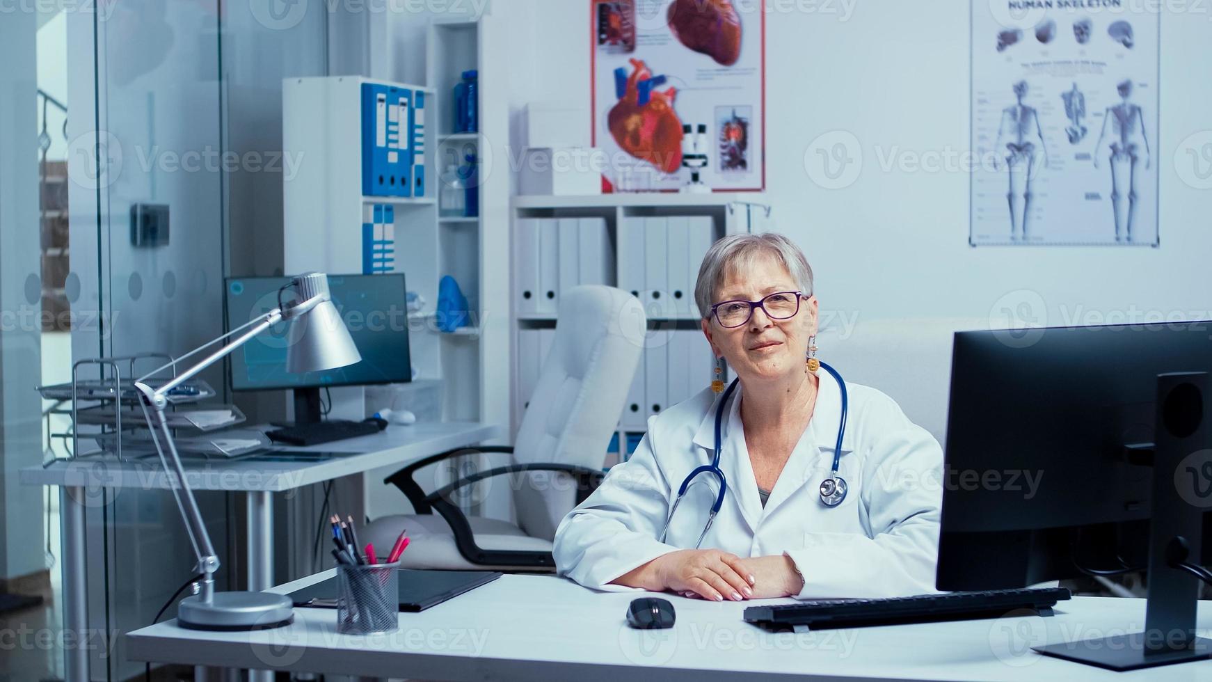 Doctora senior sonriendo a la cámara foto