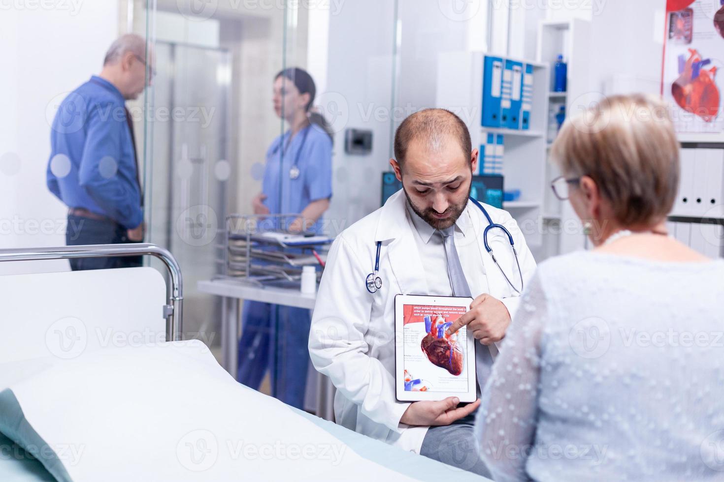 médico explicando la enfermedad de las arterias coronarias foto