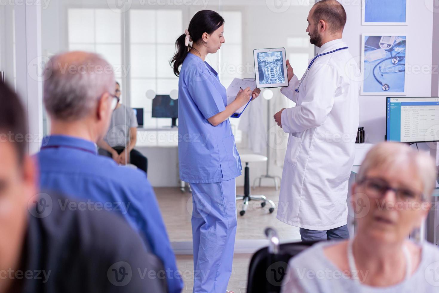 Médico especialista examinando radiografía con enfermera hopistal foto