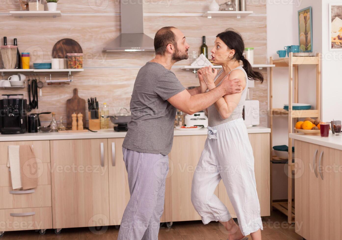 hombre agresivo amenazando con golpear a la esposa foto