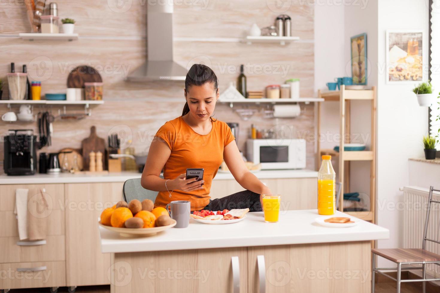 buscando en el teléfono en el desayuno foto