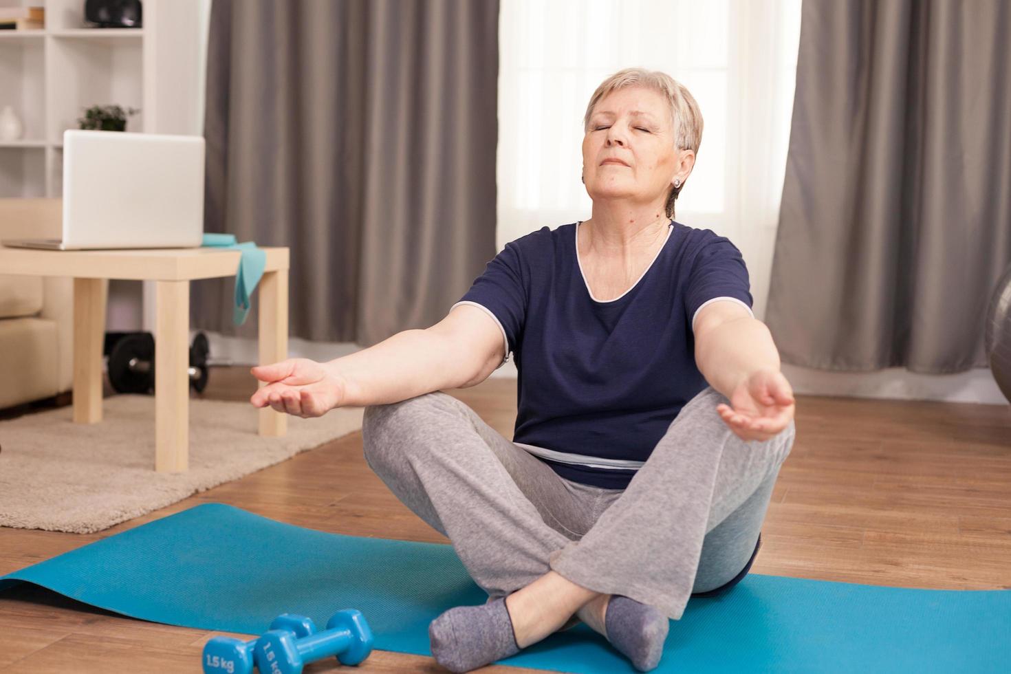 Peaceful senior woman doing yoga photo