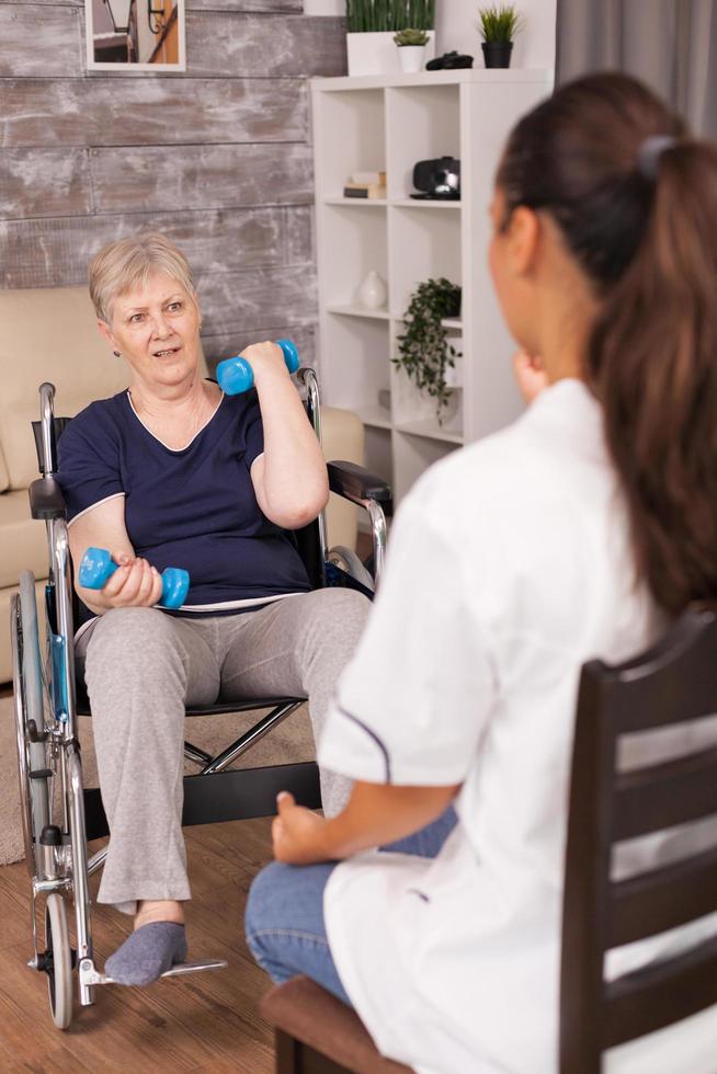 Old lady in wheelchair holding weights photo