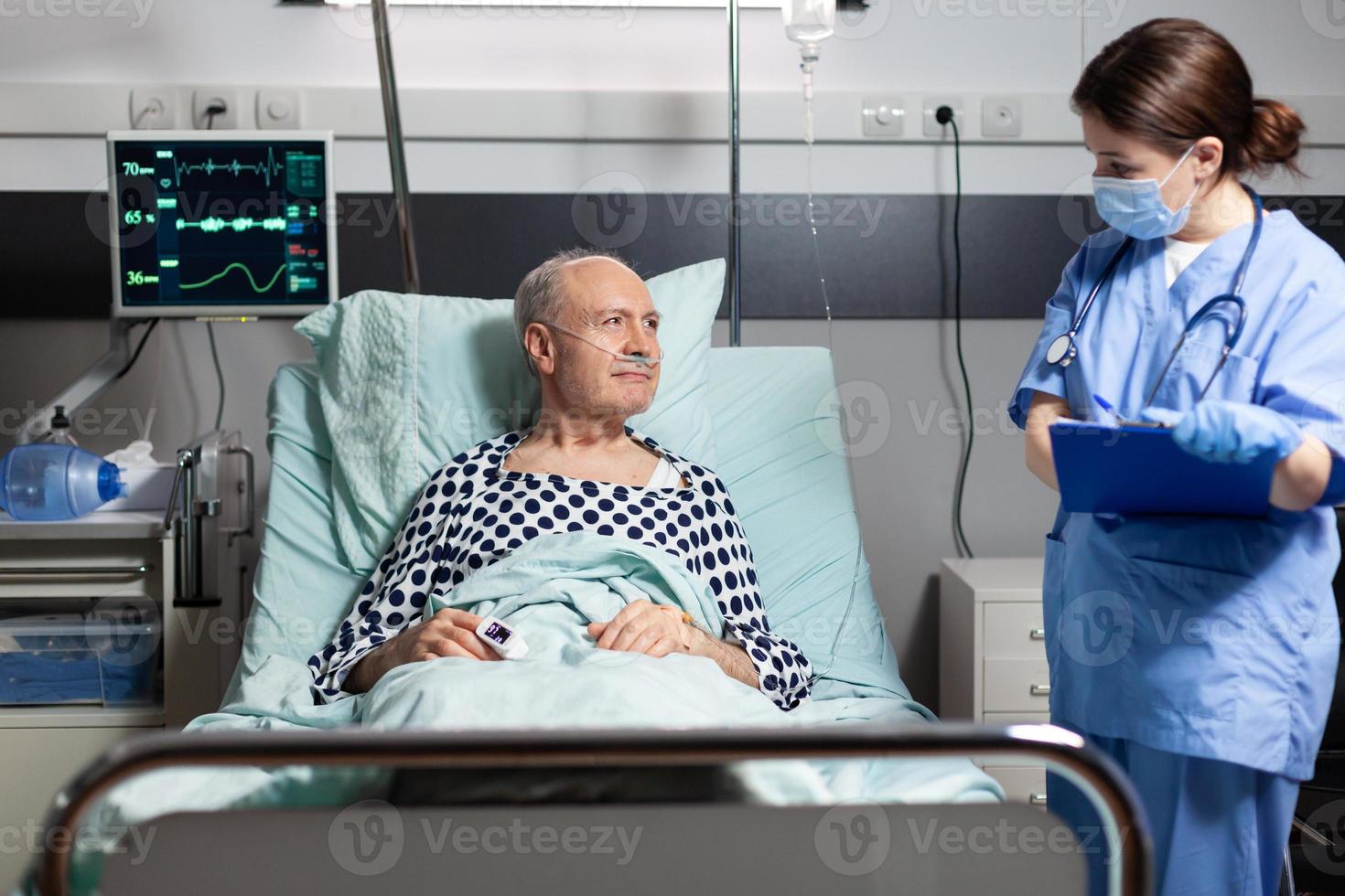 Medical nurse in scrubs with chirurgical mask taking notest on cliboard photo