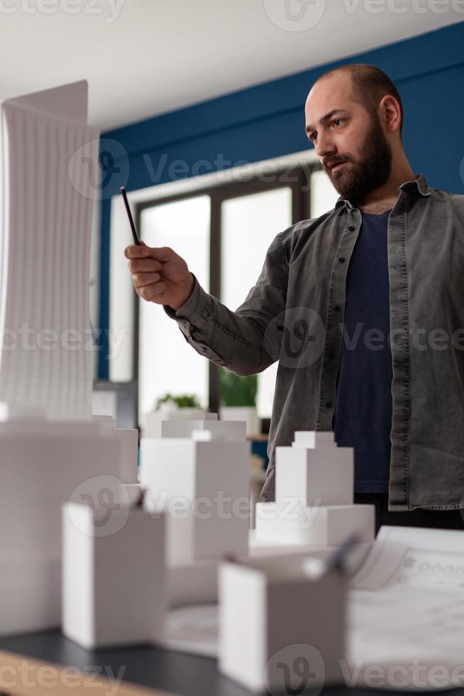 Hombre arquitecto mirando el diseño en la oficina profesional foto