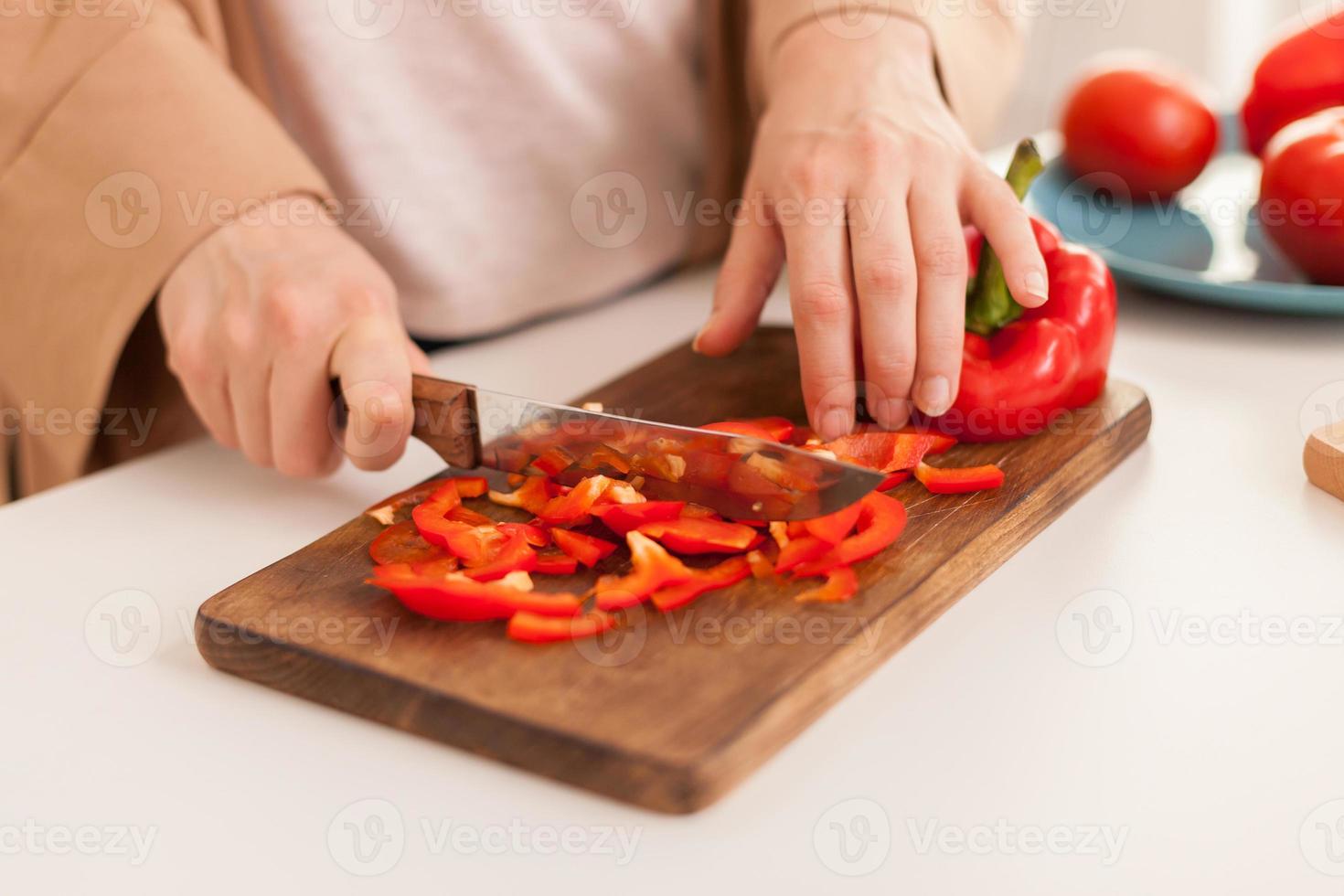 Cerca de la mano de pimiento en rodajas foto