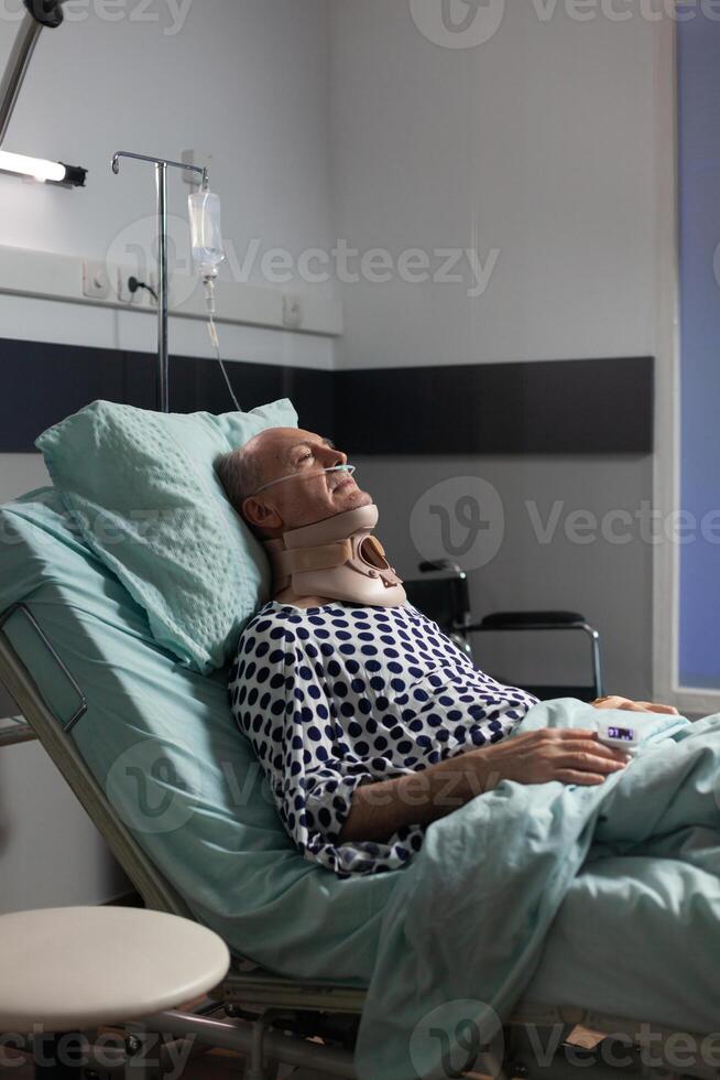 Senior man suffering after serious accident laying in hospital bed photo