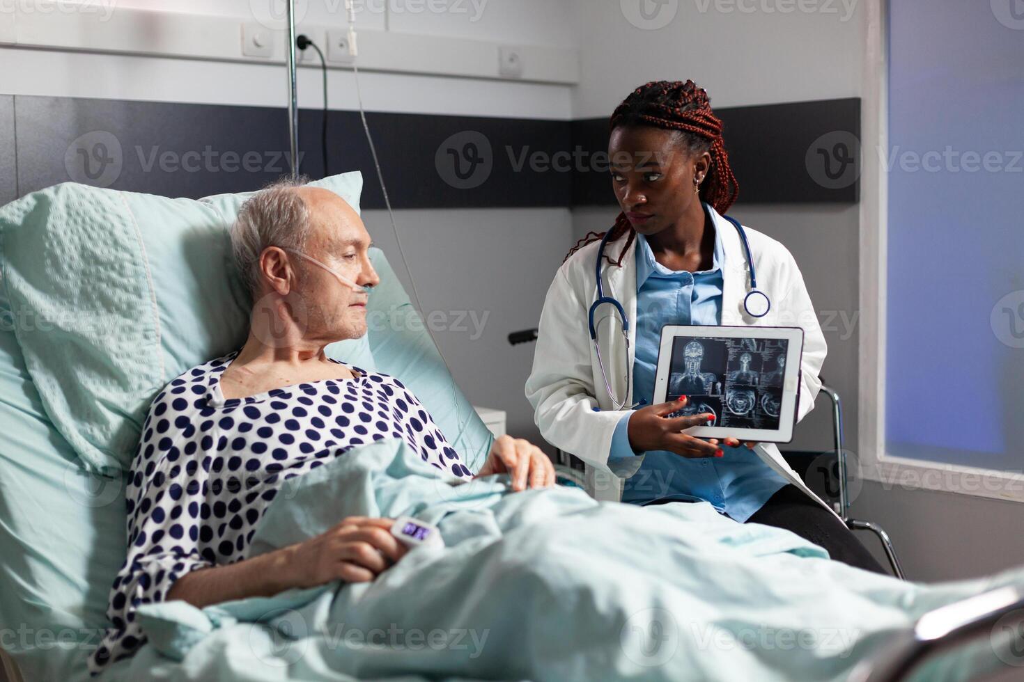 doctor sitting next to senior man explaining body trauma photo