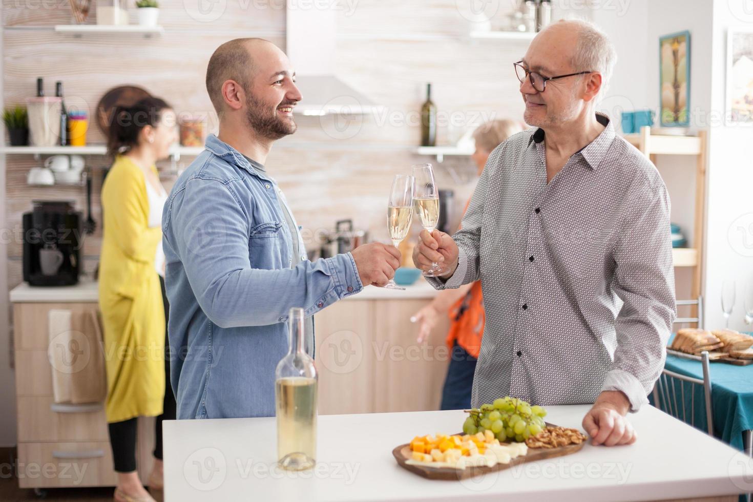 padre e hijo tintineando copas de vino foto