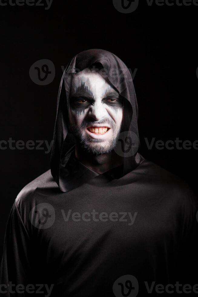 Grim reaper with a scary face isolated over black background photo