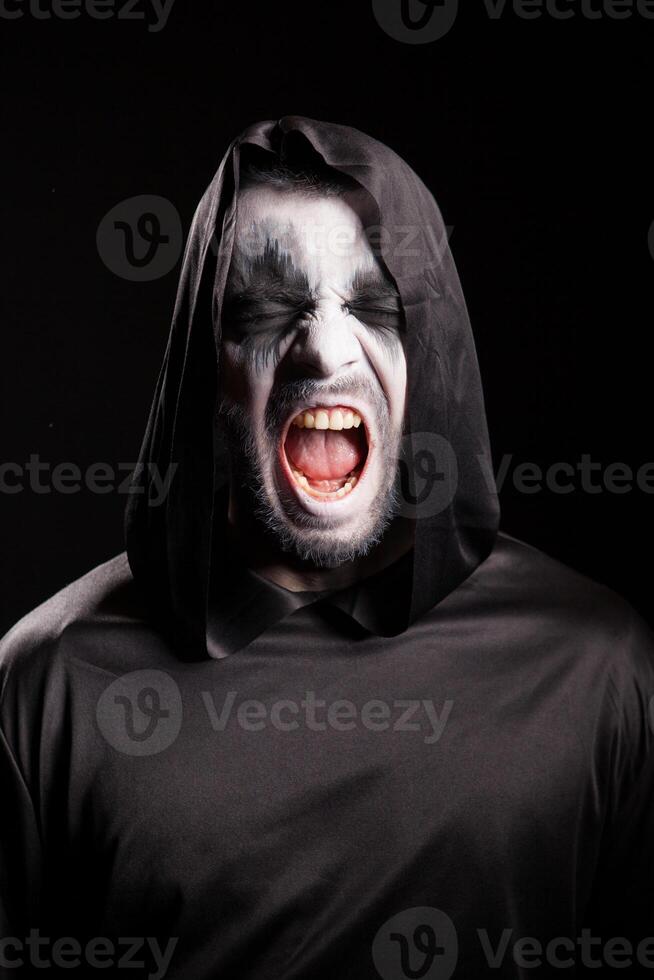 Portrait of grim reaper screaming over black background photo