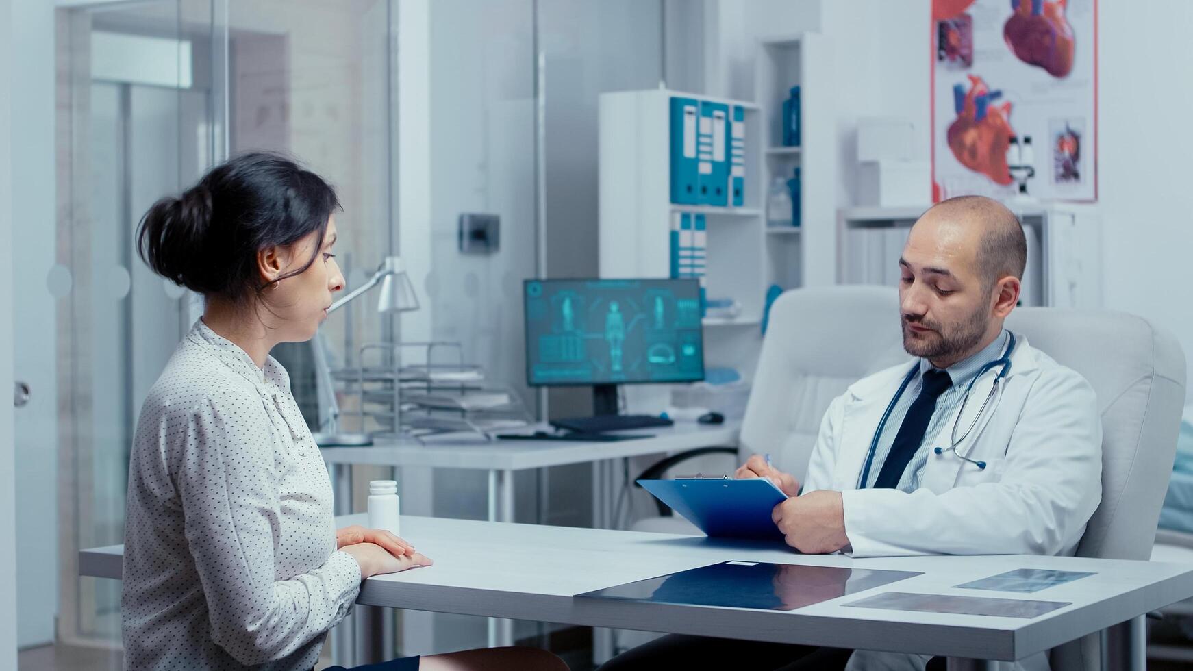 Doctor questioning young female patient photo