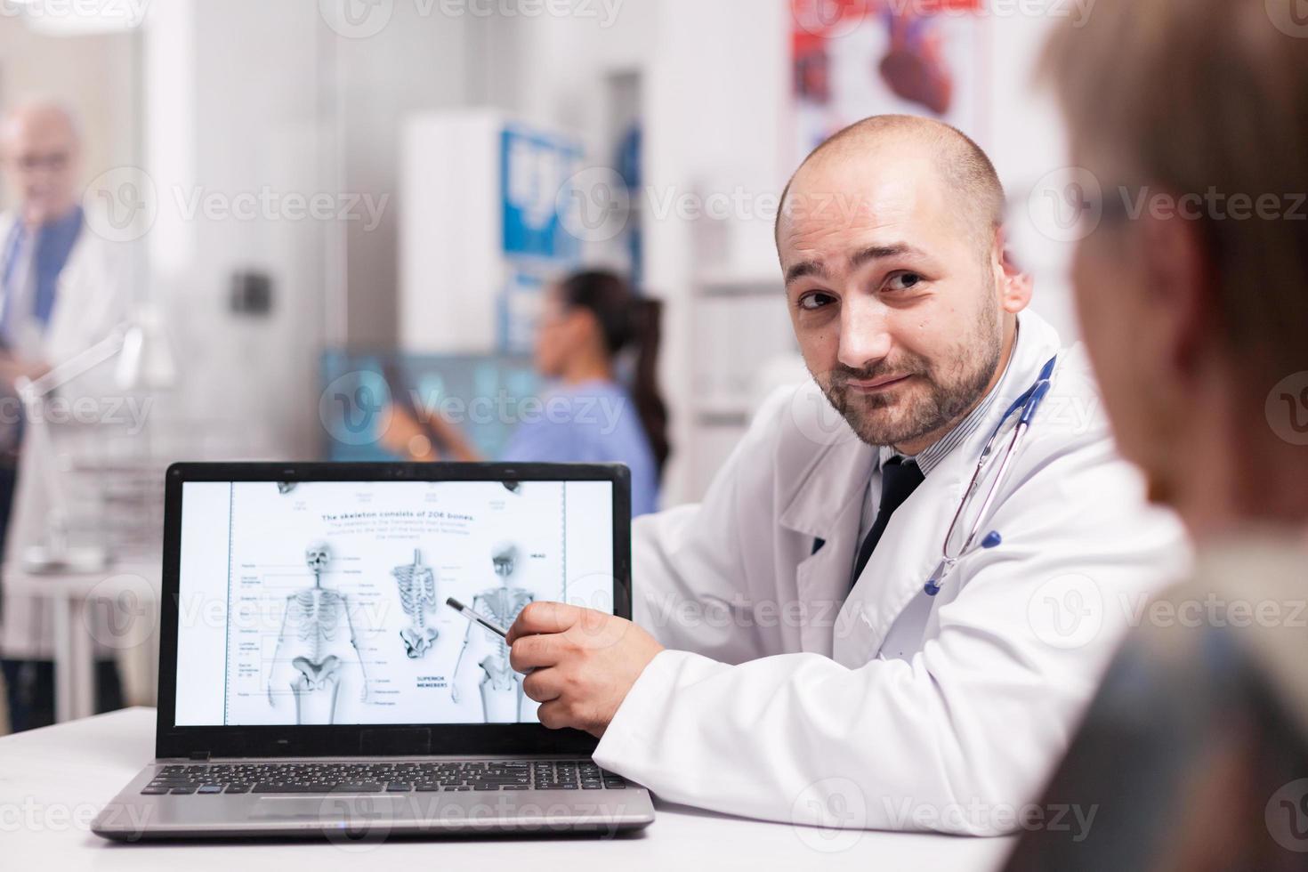 Doctor diciéndole al paciente mayor que necesita cirugía de espalda foto