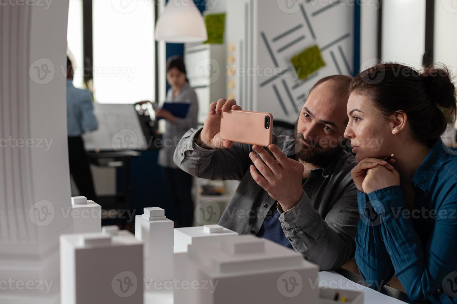 Professional architect colleagues work on smartphone photo