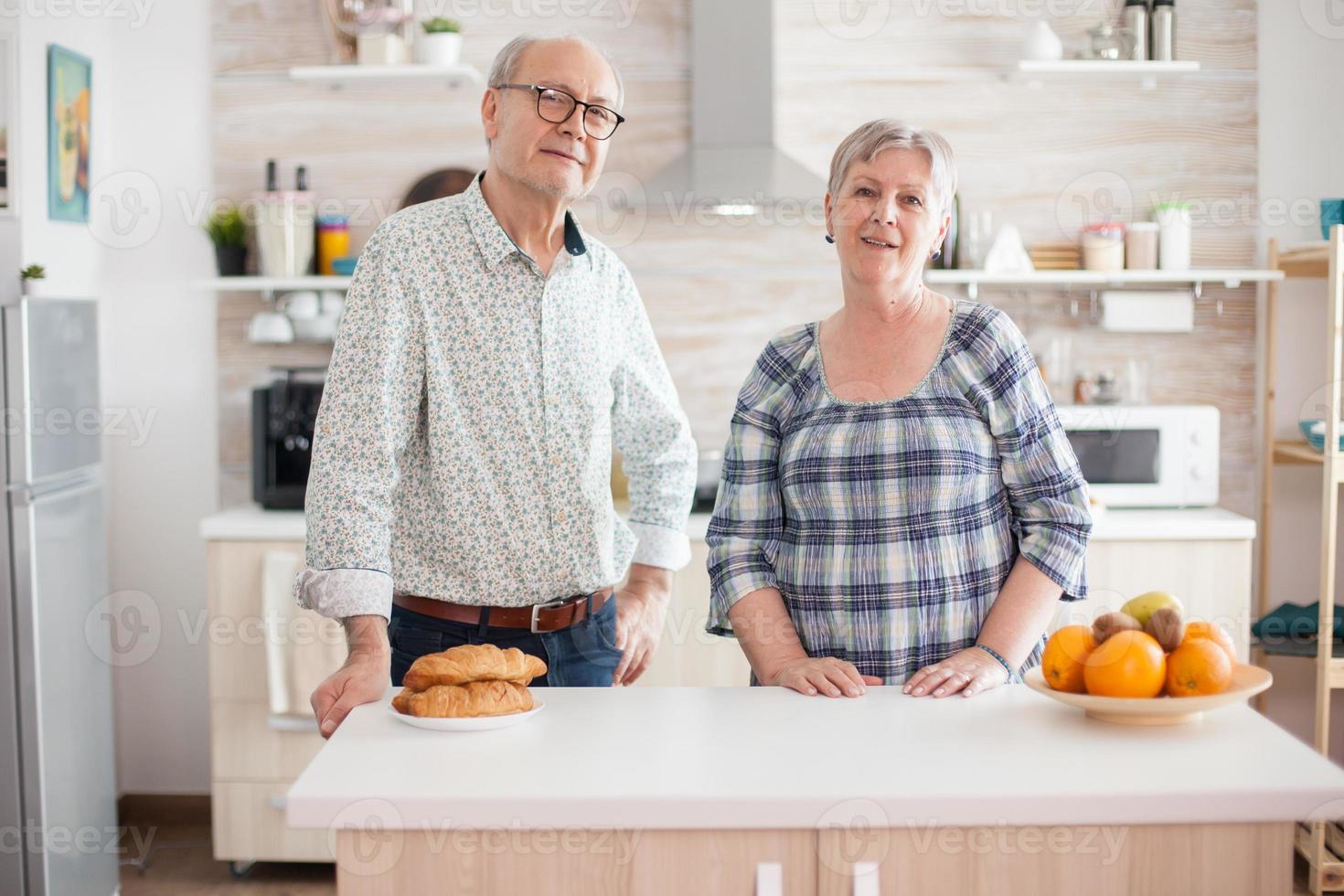 Old cheerful couple looking into camera photo