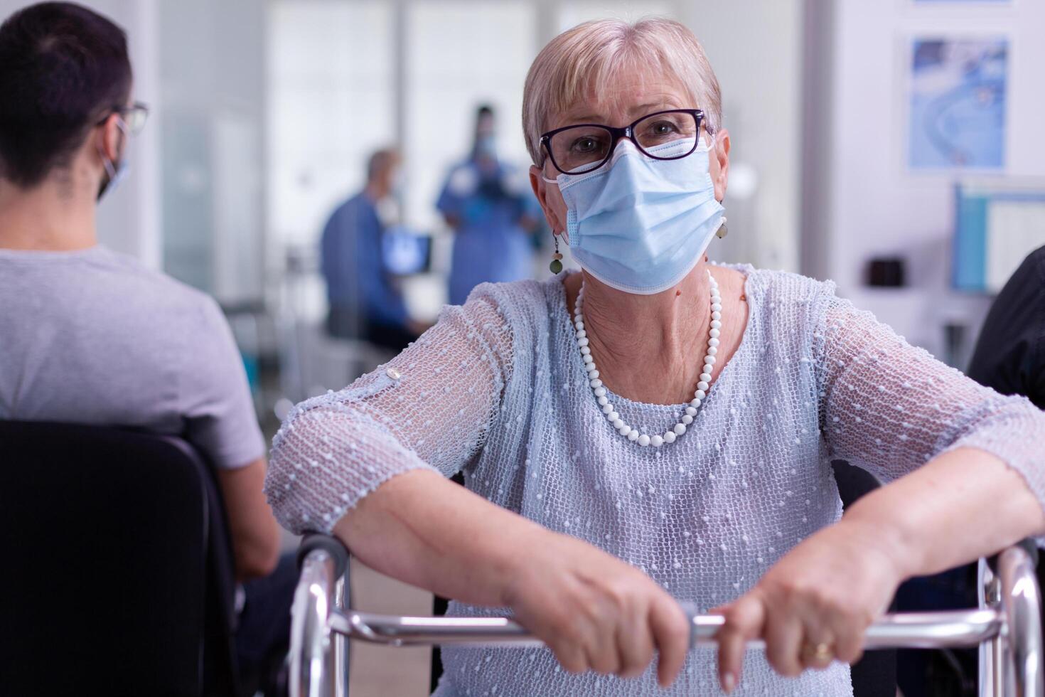 Portrait of retired disabled patient in hospital office looking at camera photo