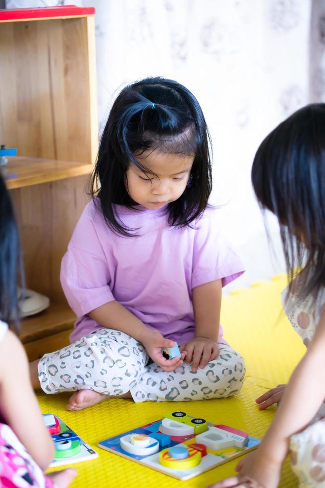 Retratos de niños asiáticos jugando juguetes de madera para el desarrollo. Fortalecer las habilidades de análisis y observación y los músculos de las manos. foto