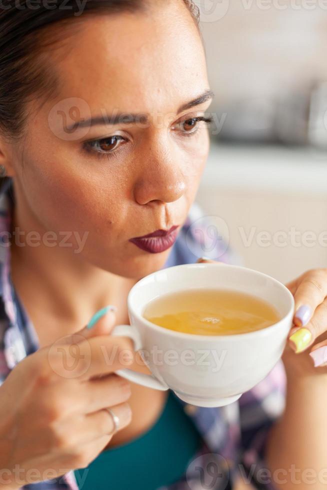 mujer tratando de beber té caliente foto