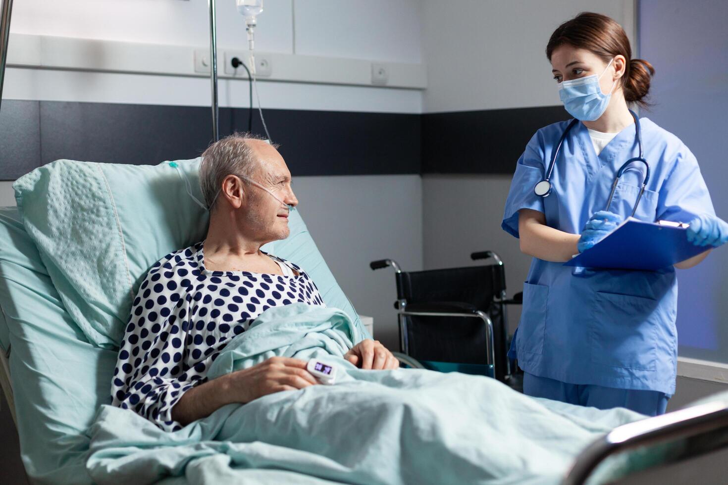 Medical nurse in scrubs with chirurgical mask taking notest on cliboard photo