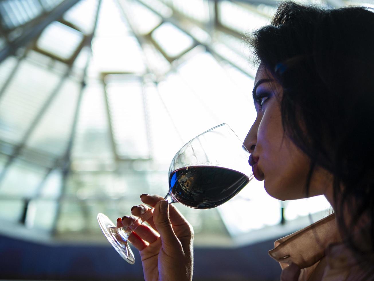 girl with beautiful lips who drinks red wine from a glass photo