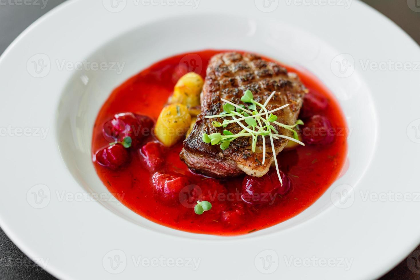 Steak from fillet of a duck with caramelized strawberry photo