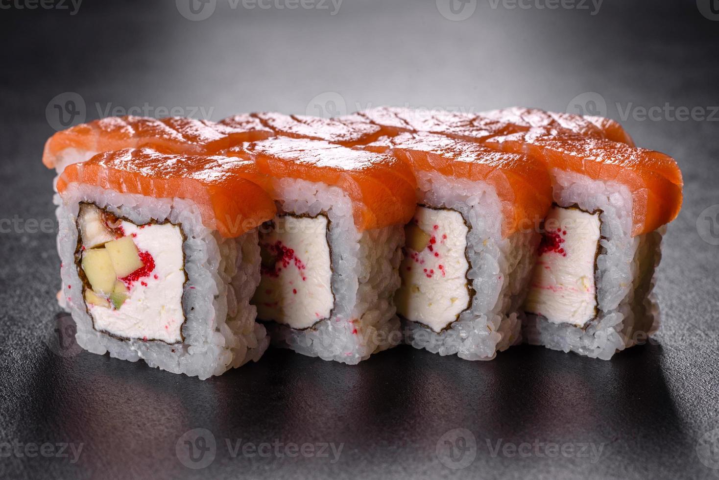 Traditional delicious fresh sushi roll set on a black background photo