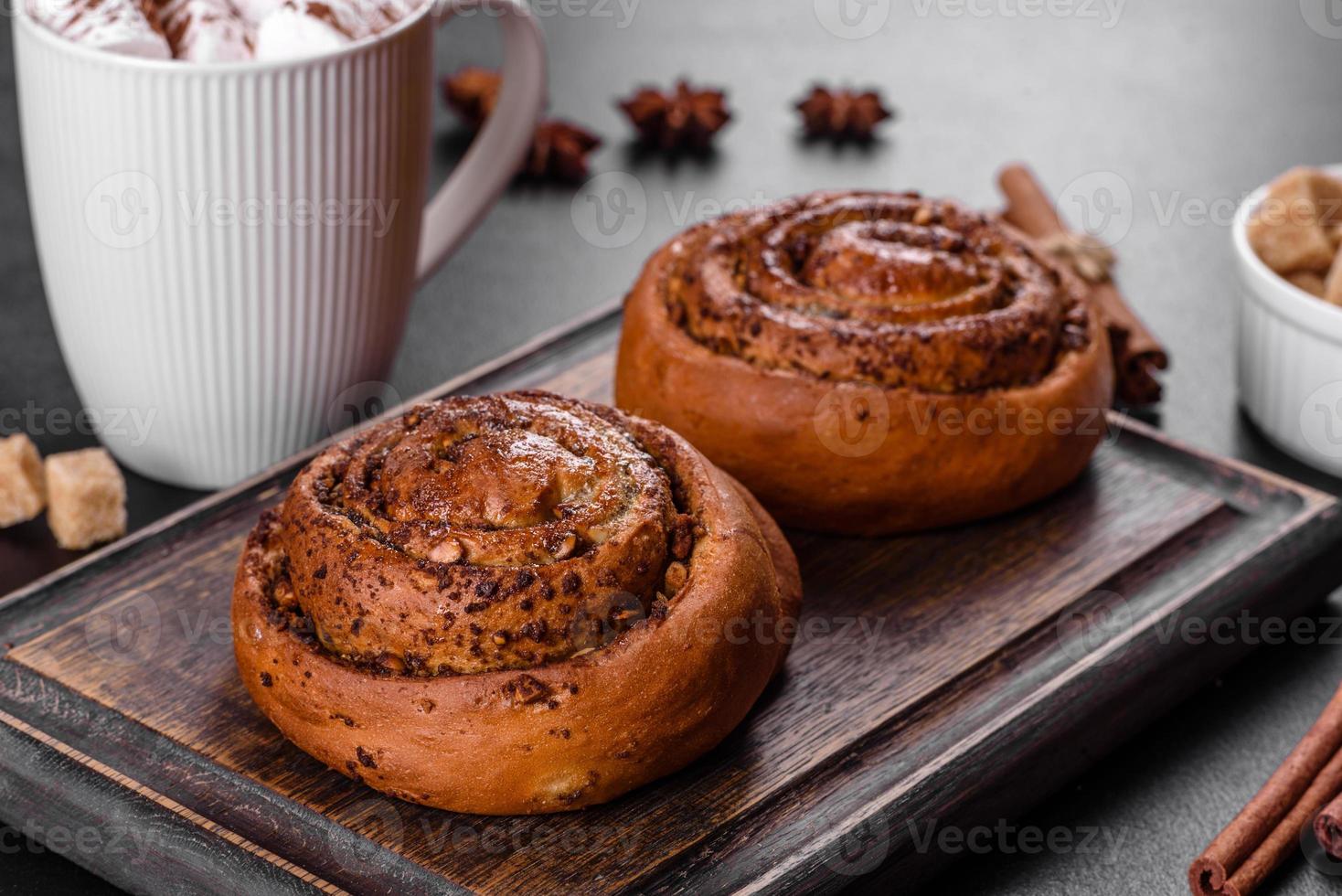 Freshly baked cinnamon roll with spices and cocoa filling on a black background photo