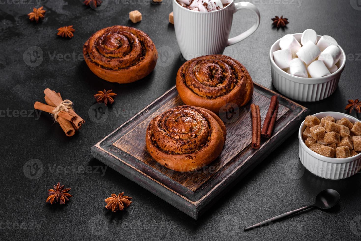Freshly baked cinnamon roll with spices and cocoa filling on a black background photo
