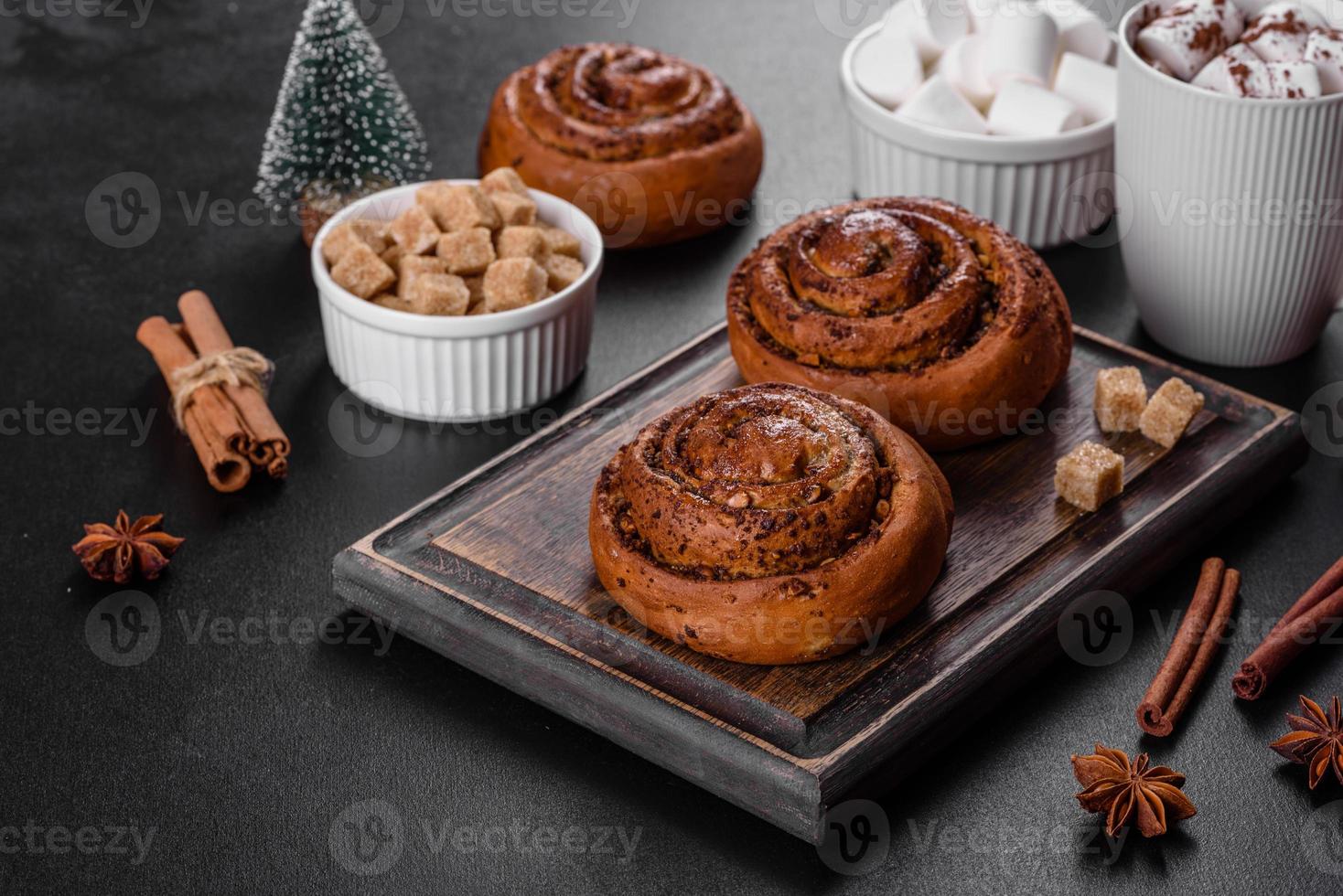 Freshly baked cinnamon roll with spices and cocoa filling on a black background photo