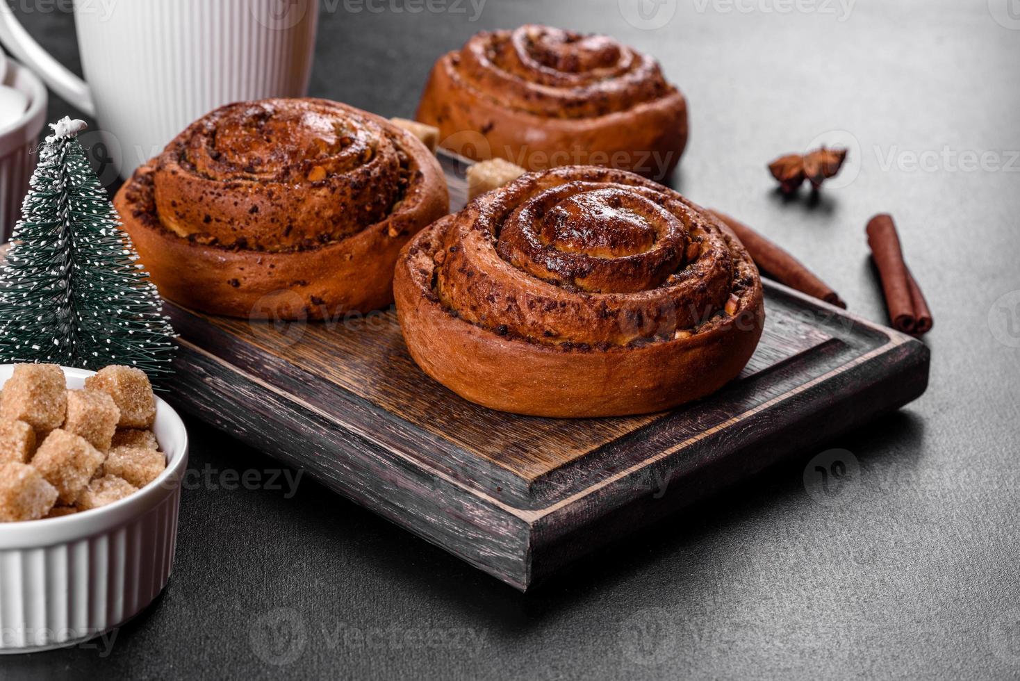 Freshly baked cinnamon roll with spices and cocoa filling on a black background photo