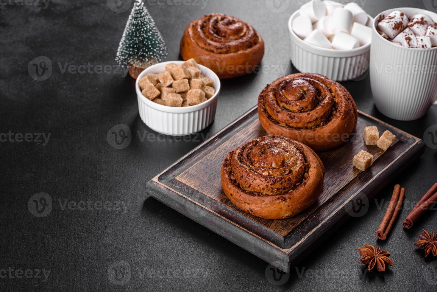 Freshly baked cinnamon roll with spices and cocoa filling on a black background photo