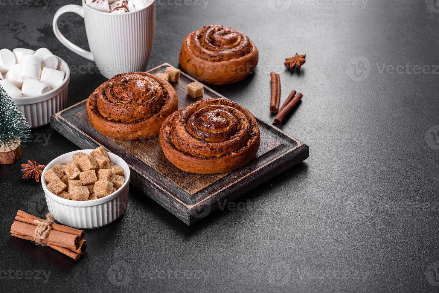 Freshly baked cinnamon roll with spices and cocoa filling on a black background photo
