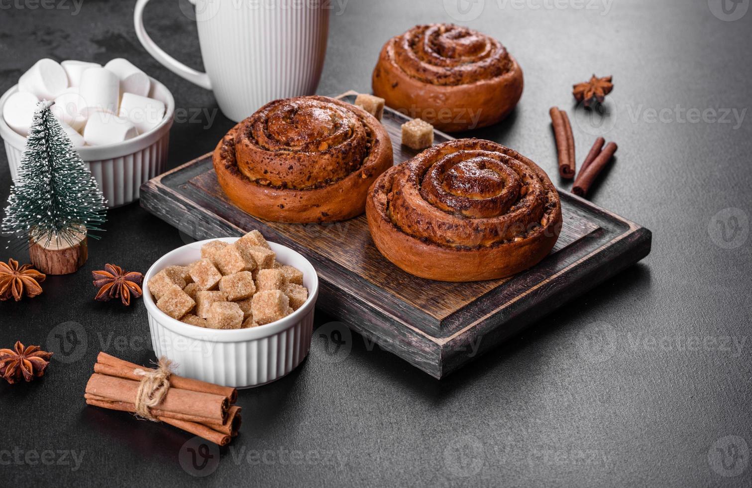 Freshly baked cinnamon roll with spices and cocoa filling on a black background photo