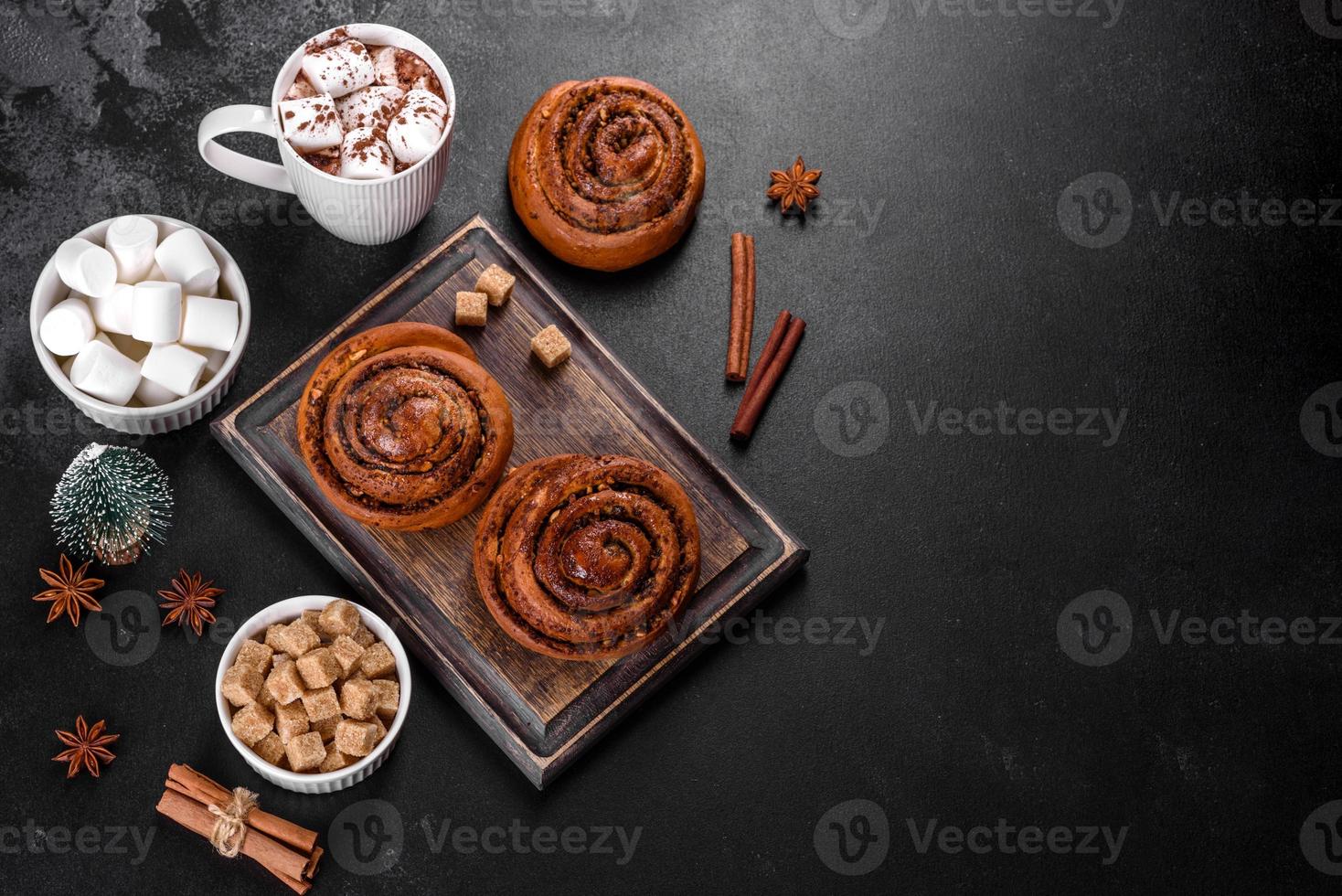 Freshly baked cinnamon roll with spices and cocoa filling on a black background photo