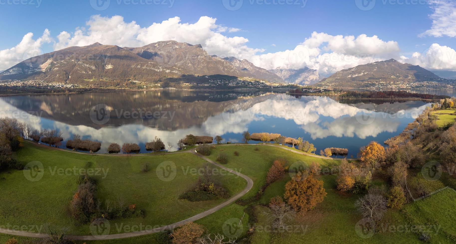 Aerial view of an alpine lake and the surrounding mountains and vegetations reflected photo