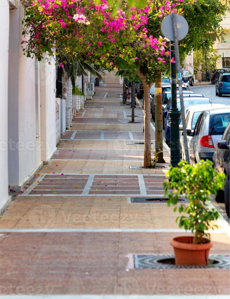 Deserted old sidewalk on Loutraki street in Greece on an early summer morning. photo