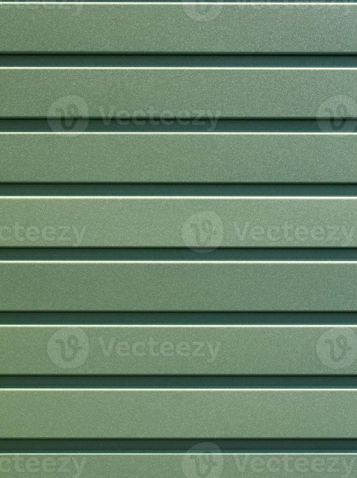 Green corrugated steel sheet with vertical guides. photo