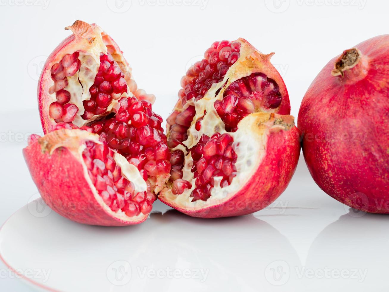 Ripe pomegranate fruit on a wite porcelain plate photo