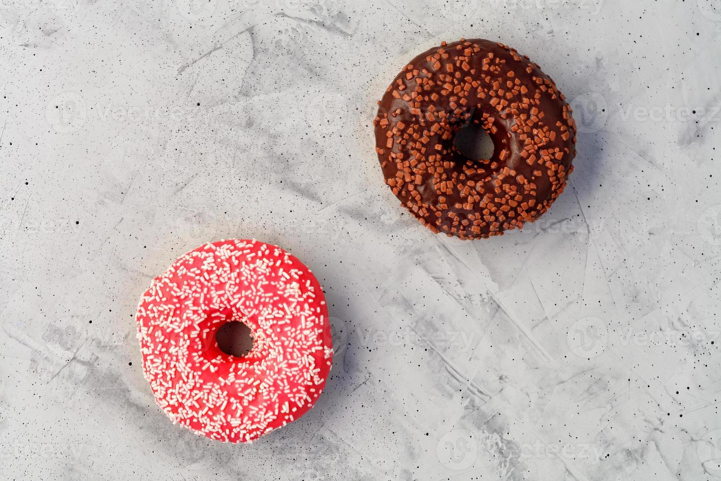 deliciosas donas de chocolate y crema sobre una superficie de hormigón gris. foto