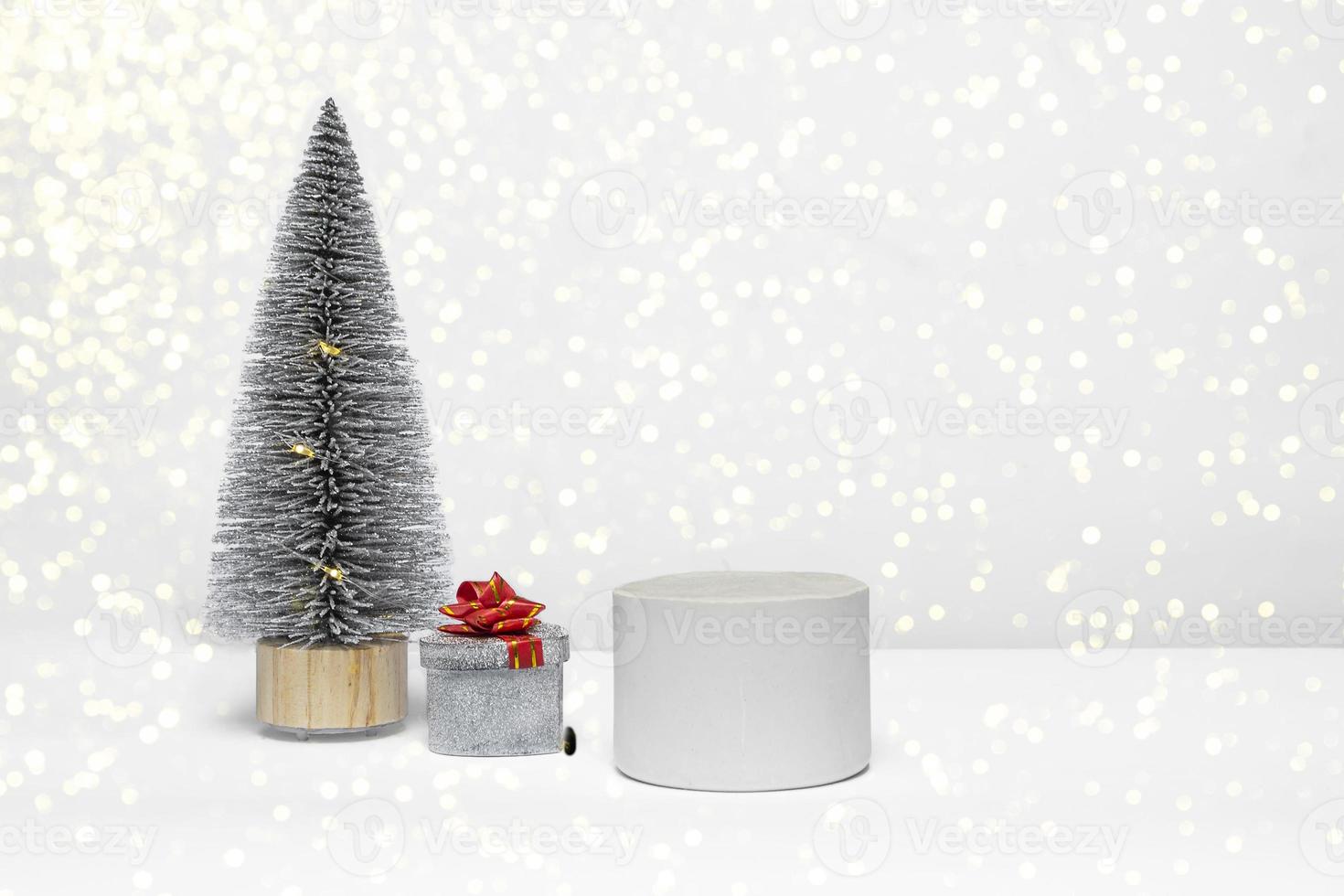 Feliz año nuevo y feliz navidad, un hermoso podio decorado con un árbol de navidad y un regalo de cerca sobre un fondo blanco. foto