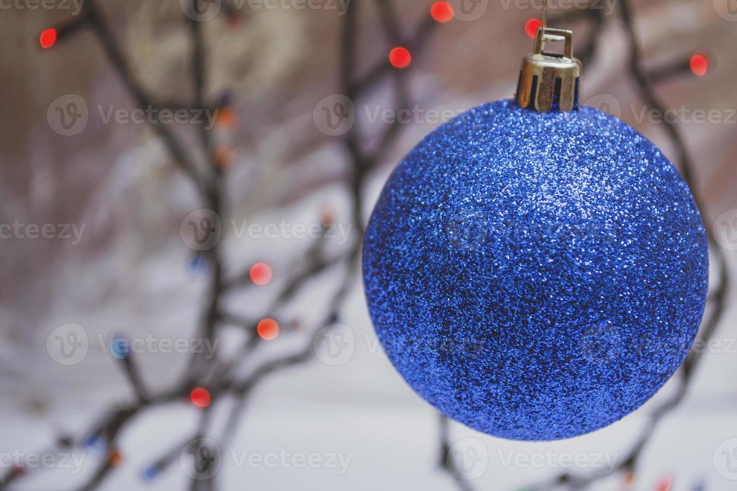 Blue shiny christmas ball isolated on bokeh background photo